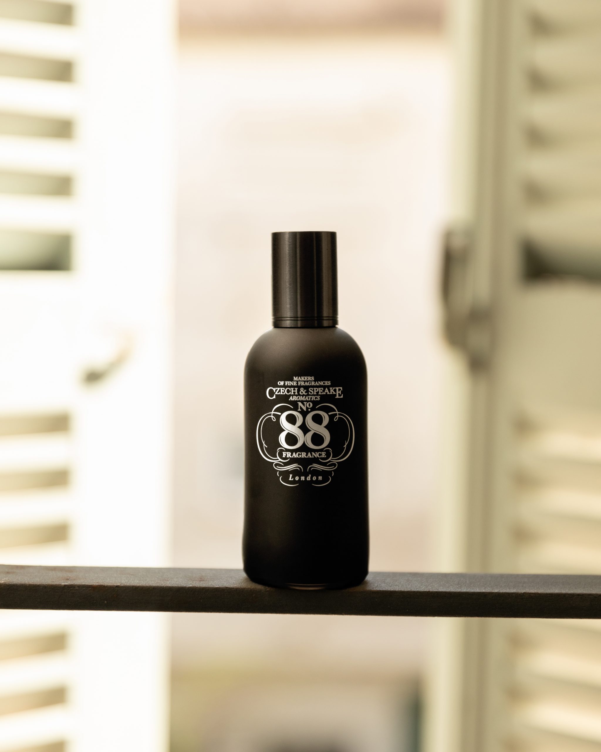 Black No.88 bottle on balcony fence in front of cream shutters