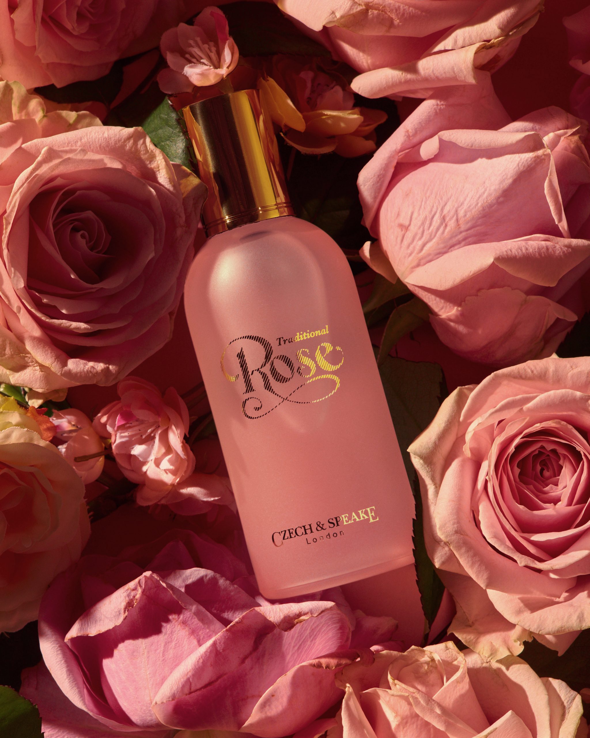 Pink rose fragrance bottle lying in roses