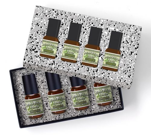 The Perfecto Fino 4-Piece 15ml Travel Set lies open, with decorative spotty lid with product stickers half covering the open set, showing four 15ml Perfecto Fino bottles. Box lies on a white background.